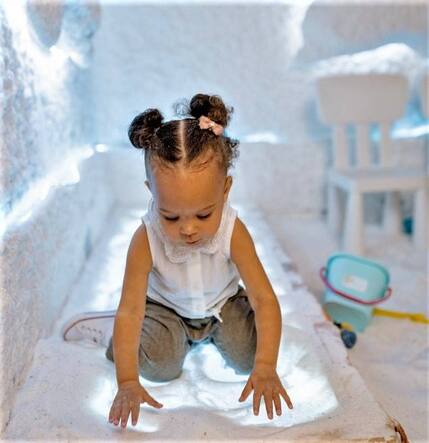 A girl playing in a salt room while taking a healing session of halotherapy