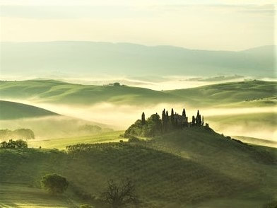 Amazing Tuscan countryside landscape with rolling hills, cypress tree, wineries, and blue sky 